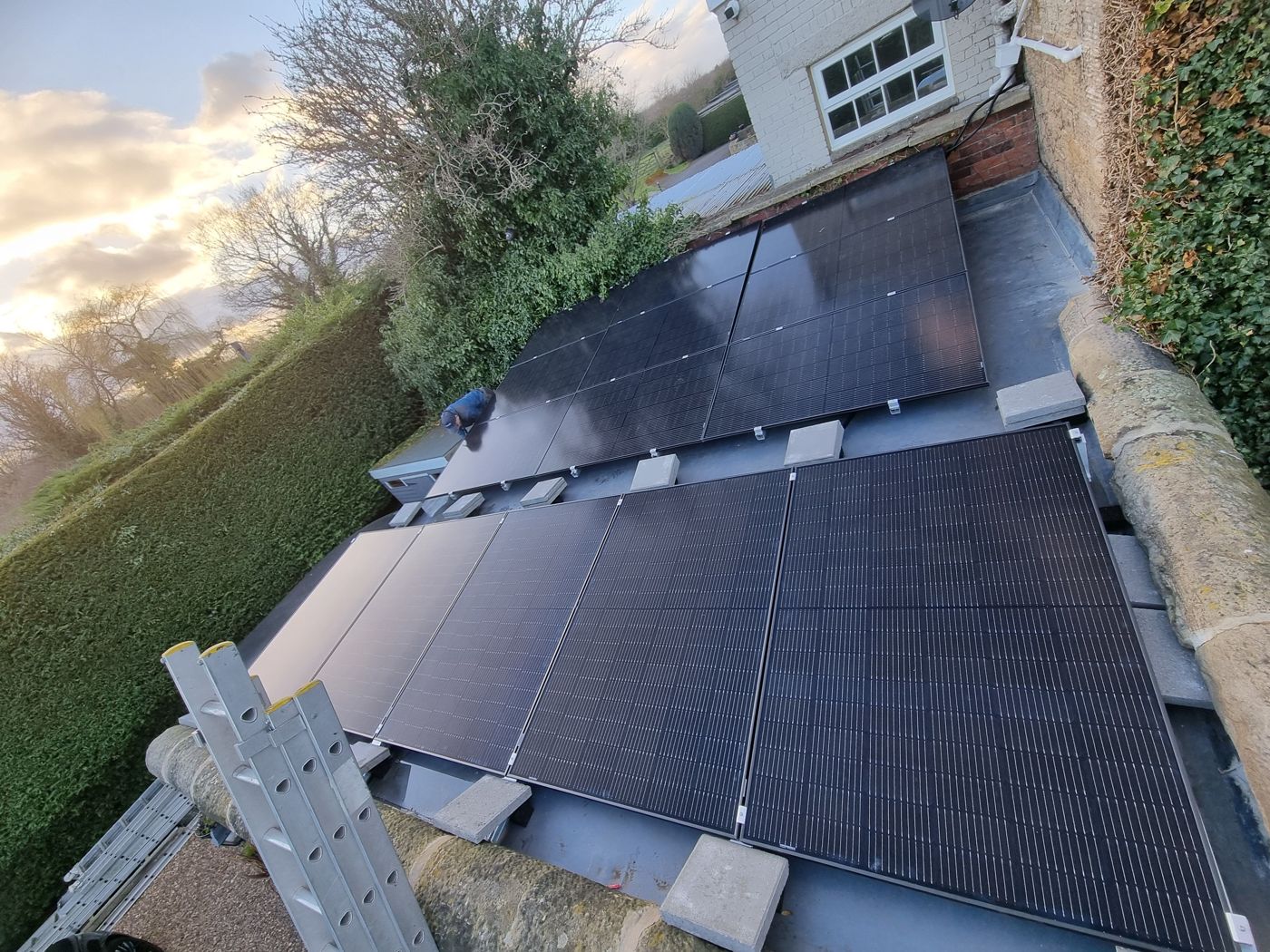 Solar panels on a flat roof, held down by concrete blocks instead of fixings
